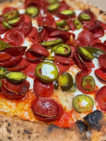 Crispy pepperoni pizza topped with jalapeño slices, fresh mozzarella, and zesty tomato sauce, perfect for pizza lovers seeking authentic flavors and a spicy kick from added peppers.