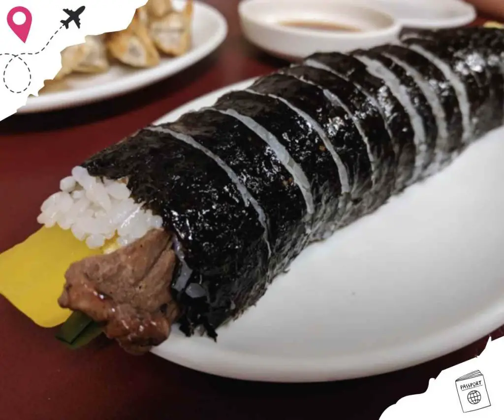 Sushi roll with rice, seaweed, and various fillings on white plate, Japanese cuisine, fresh seafood, traditional sushi dish.