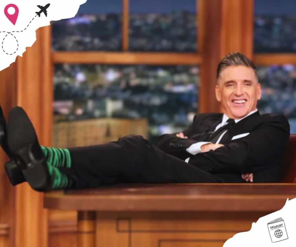 Craig Ferguson crossing his arms with his legs crossed and on his desk.