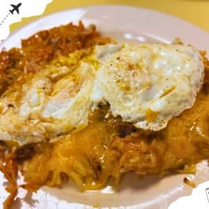 A mix of sausage and cheese with two over easy eggs on top.