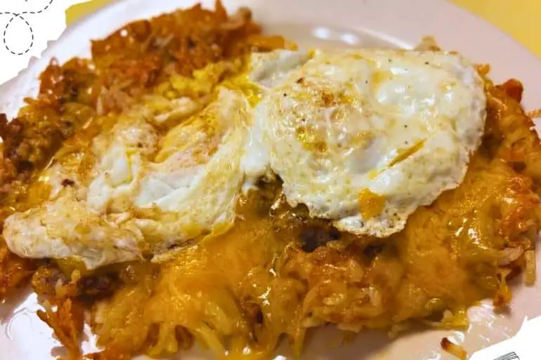 A mix of sausage and cheese with two over easy eggs on top.