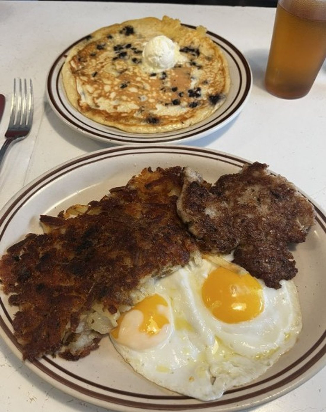 Breakfast special with hashbrowns, blueberry pancakes, sausage patties and 2 eggs sunnyside in Our Kitchen in Minneapolis, MN.