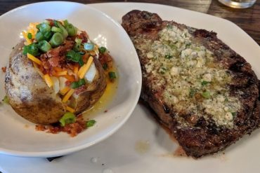 Rib Eye with Blue Cheese and Loaded Baked Potato at Manning's Steaks and Spirits located in Lakewood,Colorado.
