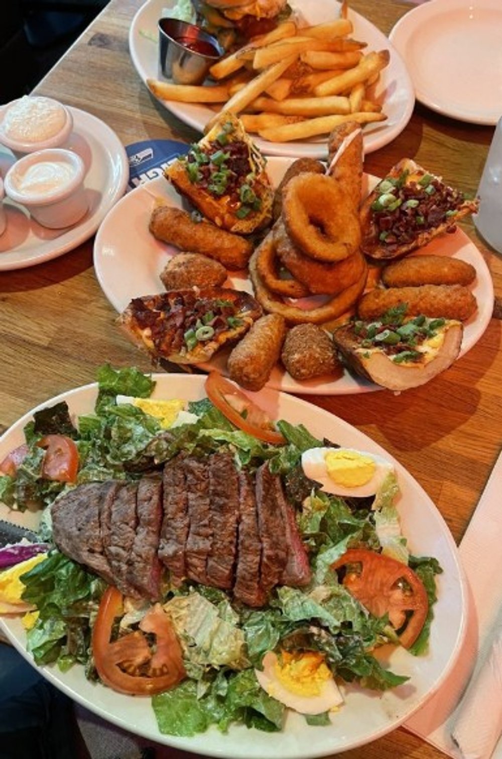 Steak salad(bottom), combo app (middle), avocado Swiss burger (top) and huckleberry vodka lemonade