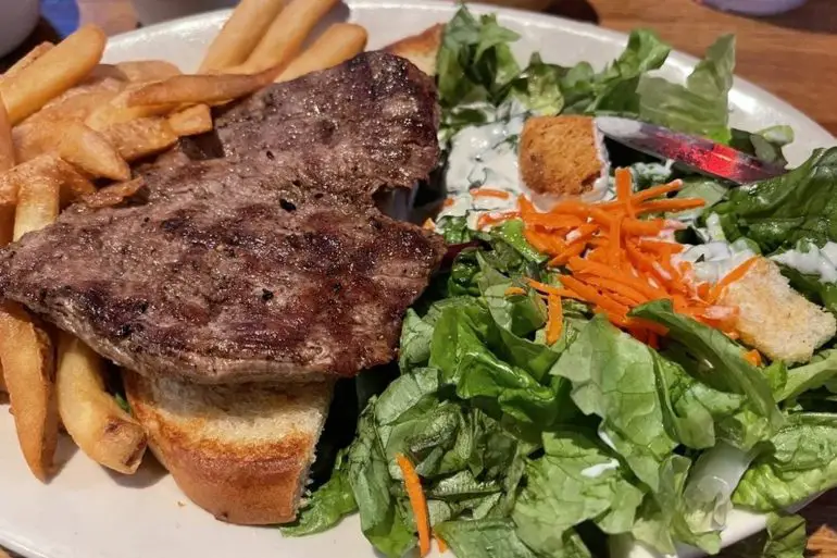Tenderloin steak fries and salad in The Pumphouse Bar & Grill located in Bellevue, WA.