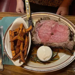 A perfect prime rib paired with fries and sauce.
