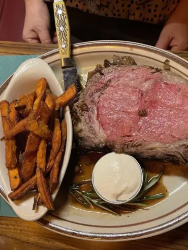 A perfect prime rib paired with fries and sauce.