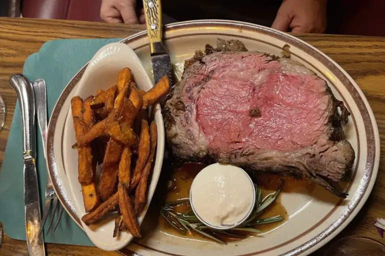 A perfect prime rib paired with fries and sauce.