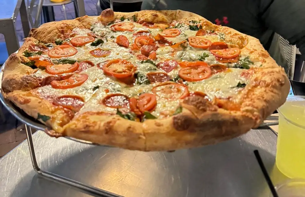 Pepperoni, spinach & tomato pizza with house sauce.