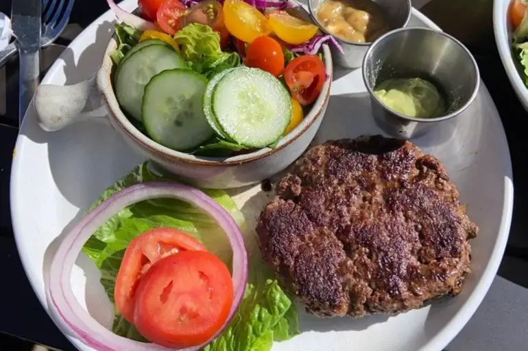 Grass fed burger sans bun with side salad at Good Kitchen + Market located in Marietta, GA.