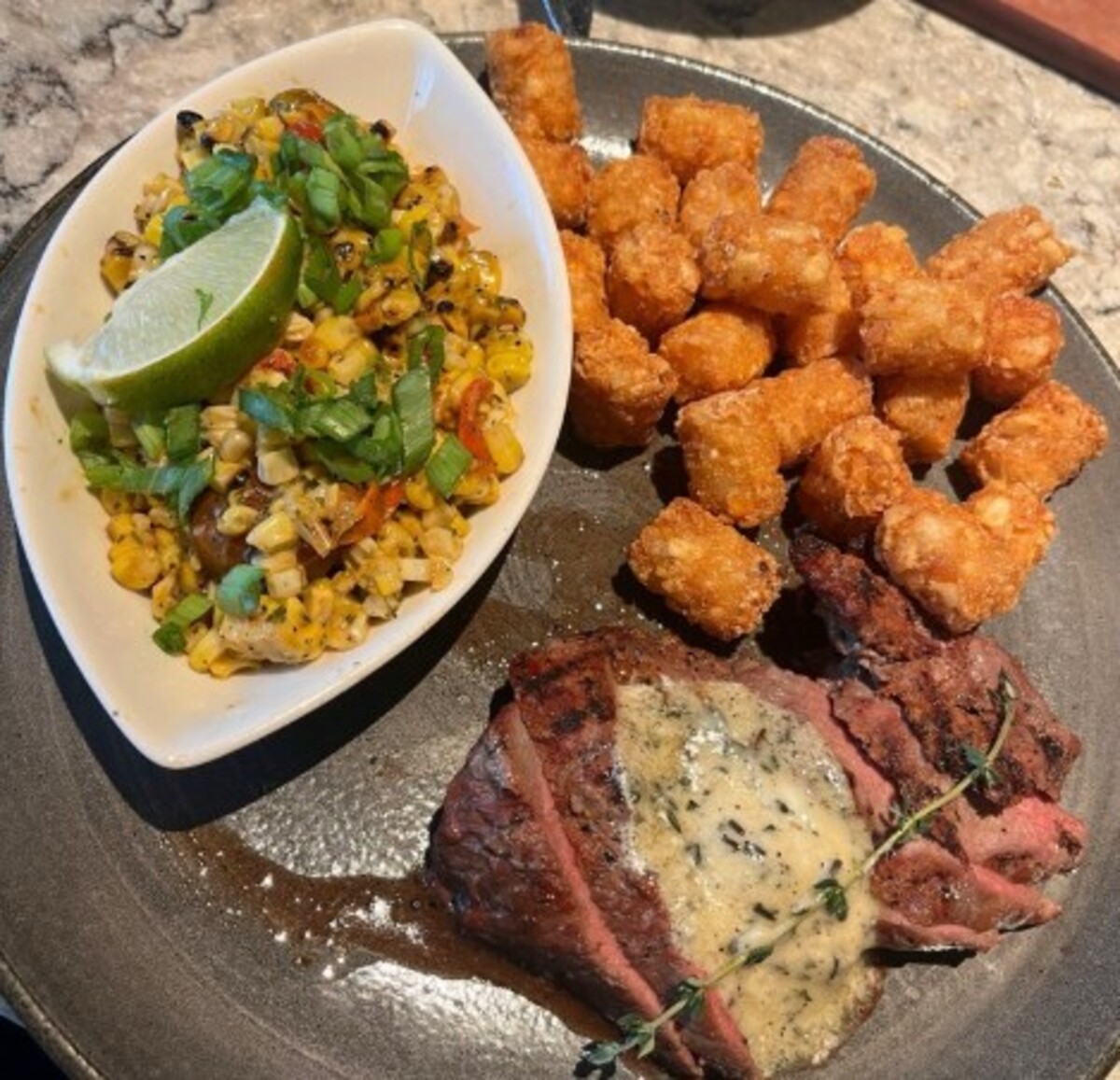 Roasted Garlic Sirloin*, Grilled Street Corn, Tater Tots at Firebirds Wood Fired Grill located in Murfreesboro, TN. 