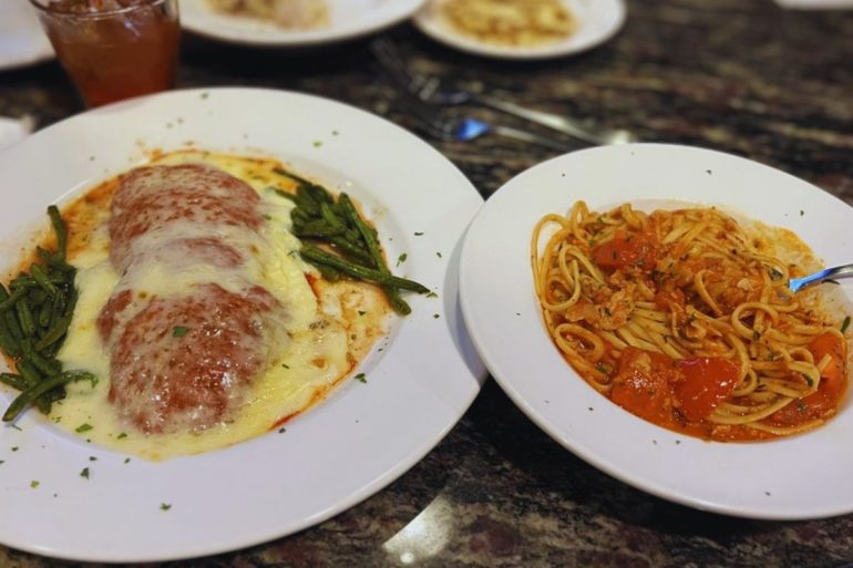 Veal Parm topped with provolone on the left and linguine with red clam sauce on the right